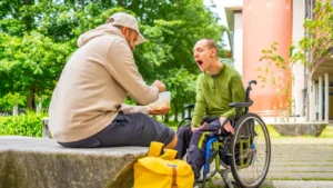 Kille med cerebral pares blir matad i en park av sin personliga assistent